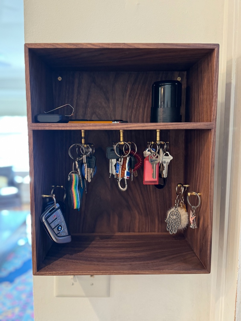 Walnut Key Cabinet: Hung by the door, loaded with keys